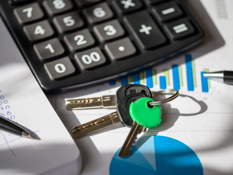 Calculator, keys, and financial documents on a desk