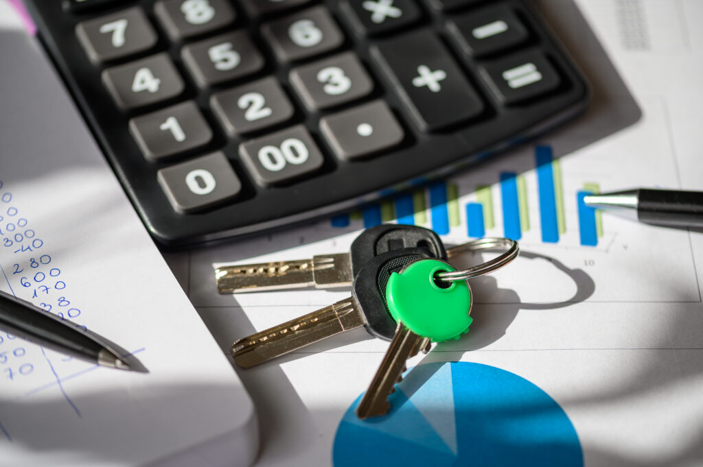 Calculator, keys, and financial documents on a desk